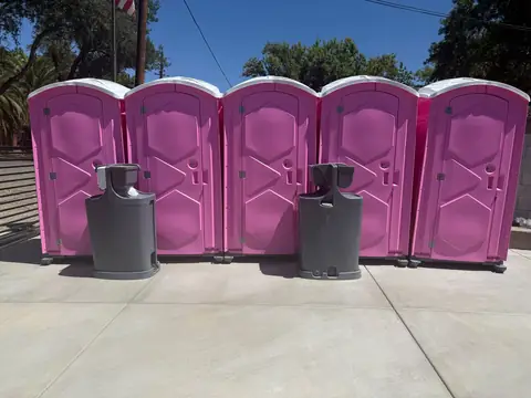 Pink event porta potties with two hand-wash stations in front